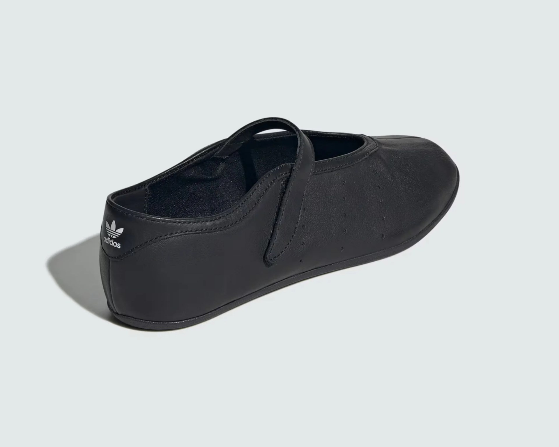 Black leather Adidas Mary Jane shoe with a strap and logo on the heel.
