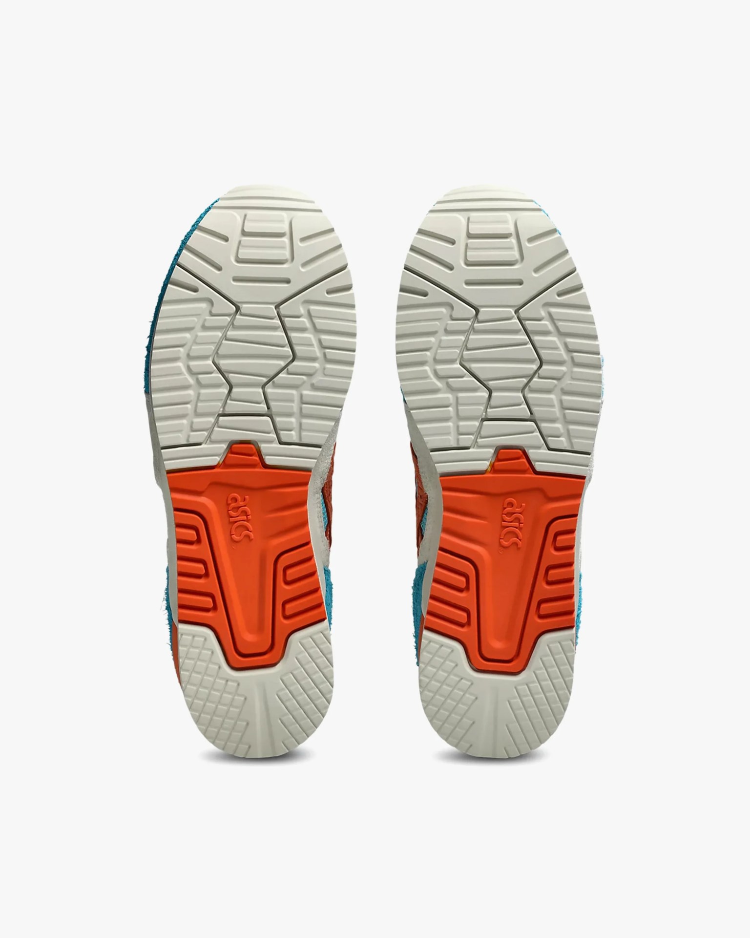 Pair of white and orange Asics sneaker soles with textured grip pattern.
