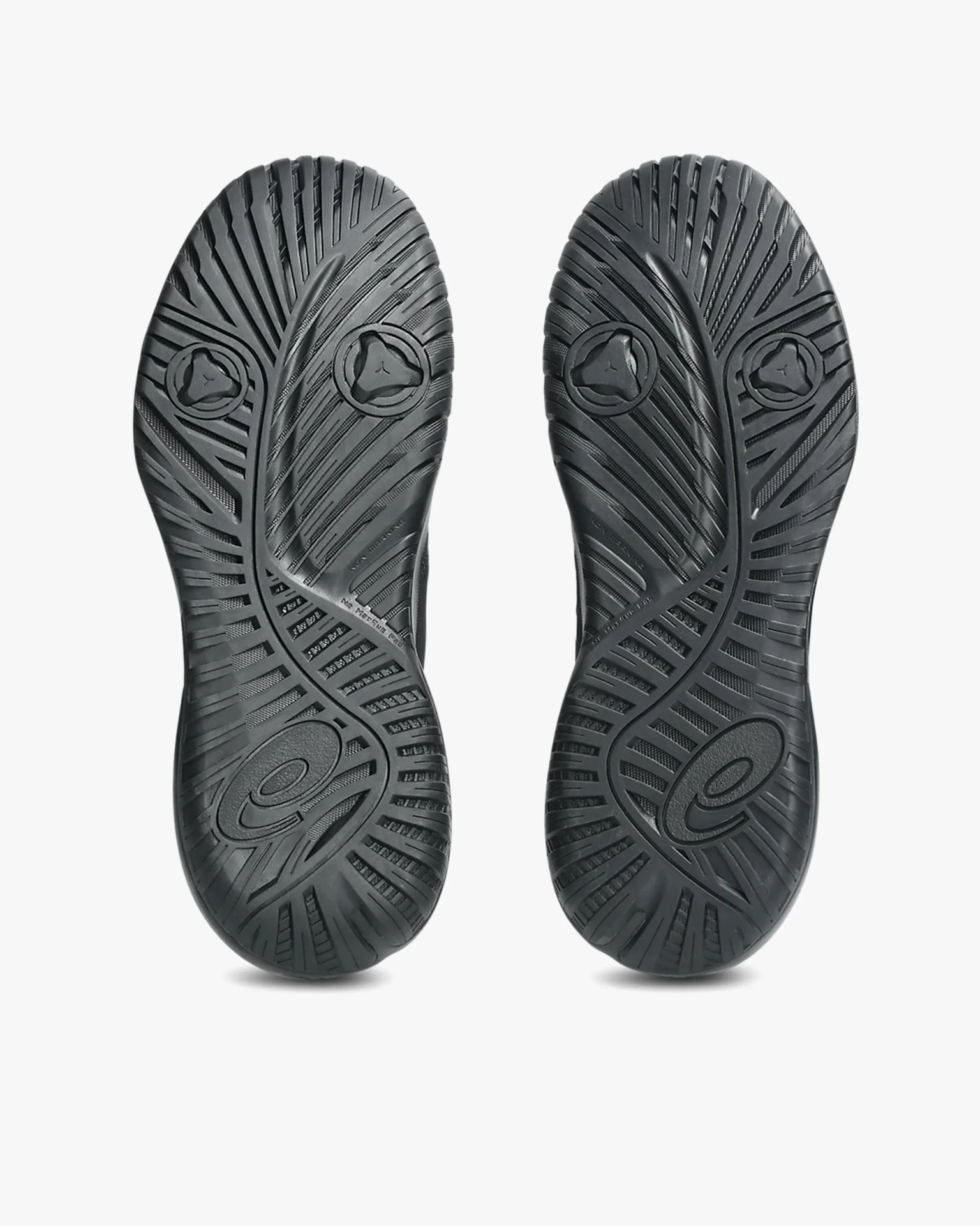 Black rubber shoe soles with intricate tread patterns and circular traction elements.