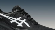 Close-up of a black ASICS sneaker with white logo and textured leather upper.