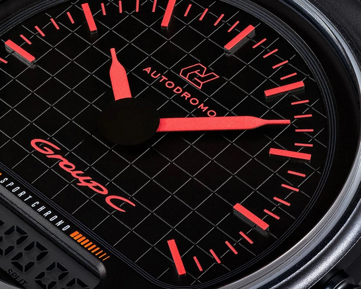 Close-up of a black watch face with red hour markers and hands, featuring "AUTODROMO" and "Group C" text.