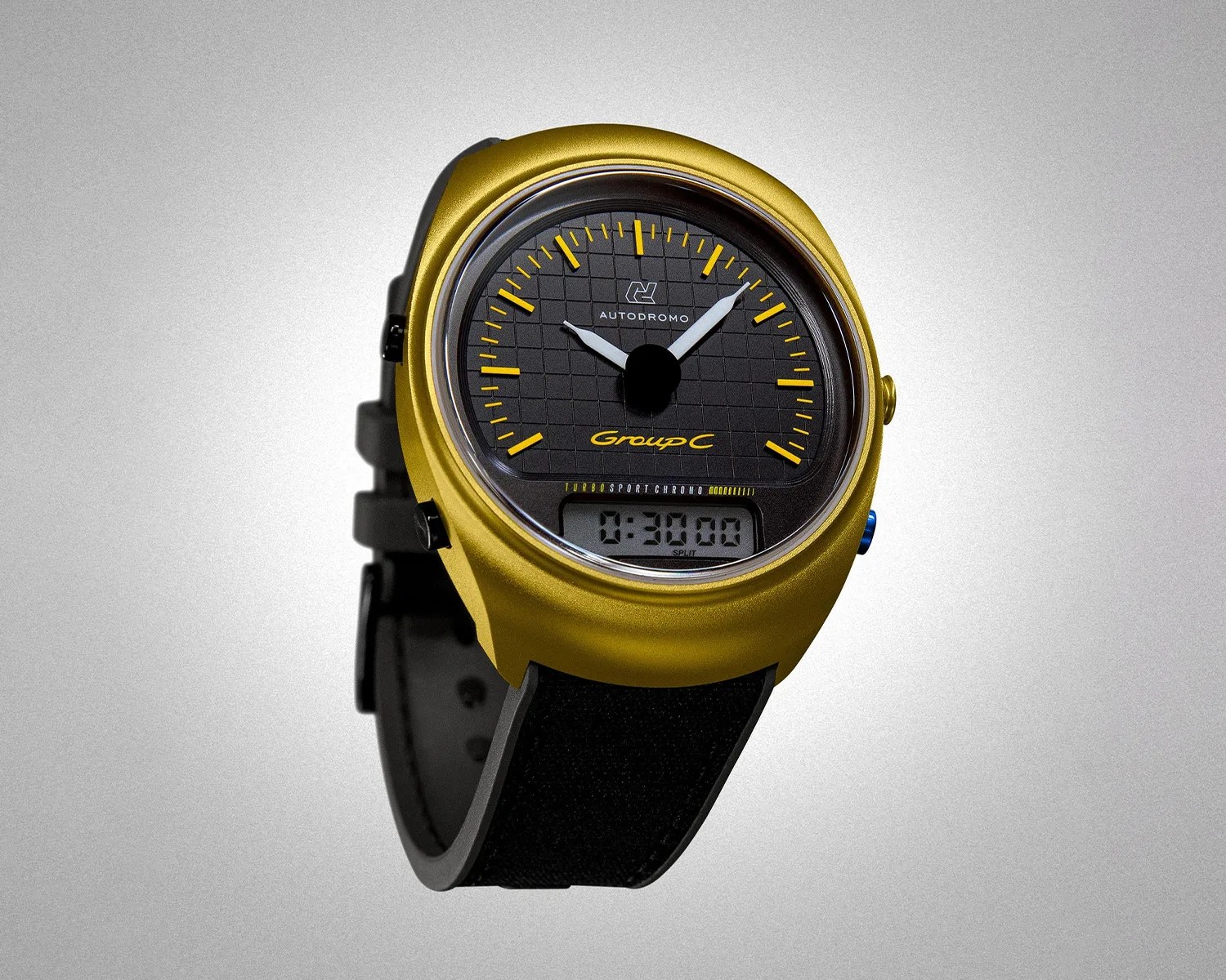 Gold-cased Autodromo Group C watch with black dial, yellow markers, white hands, digital display, and black strap.