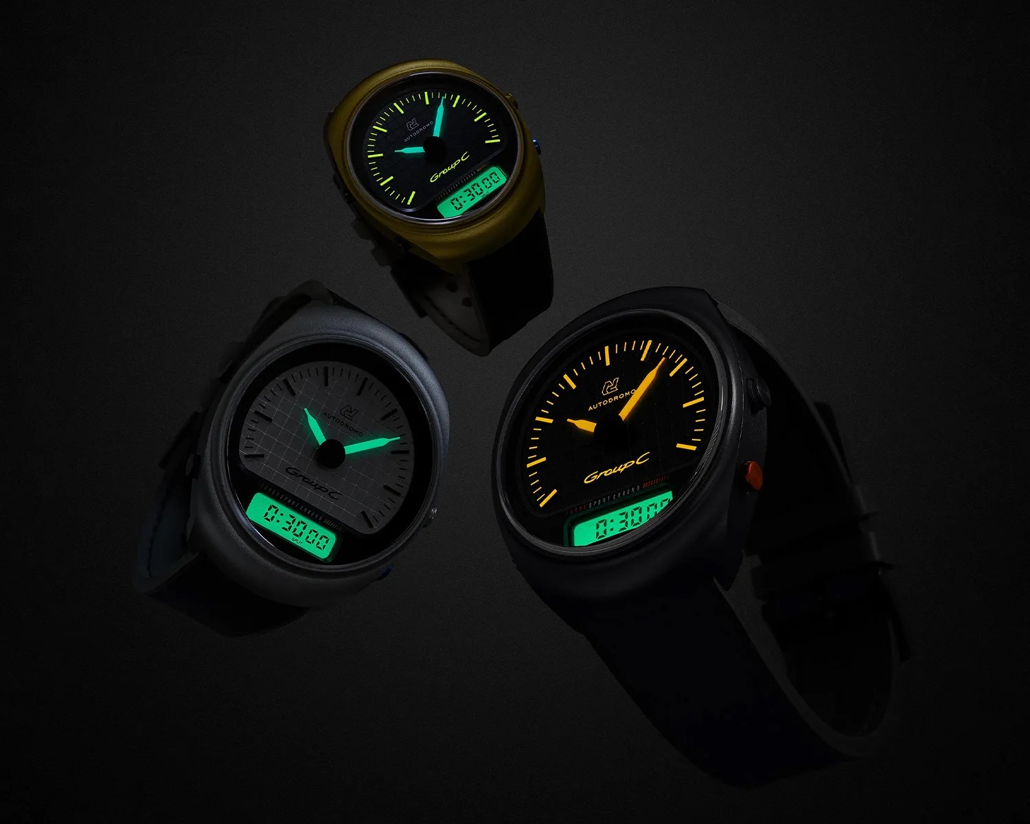 Three Autodromo Group C wristwatches with illuminated hands and digital displays on a black background.
