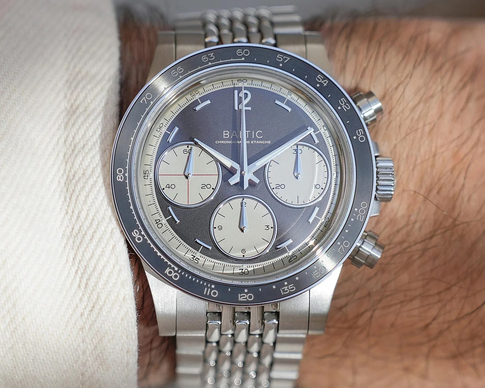 Silver Baltic chronograph wristwatch with gray dial and three white subdials on a metal bracelet.
