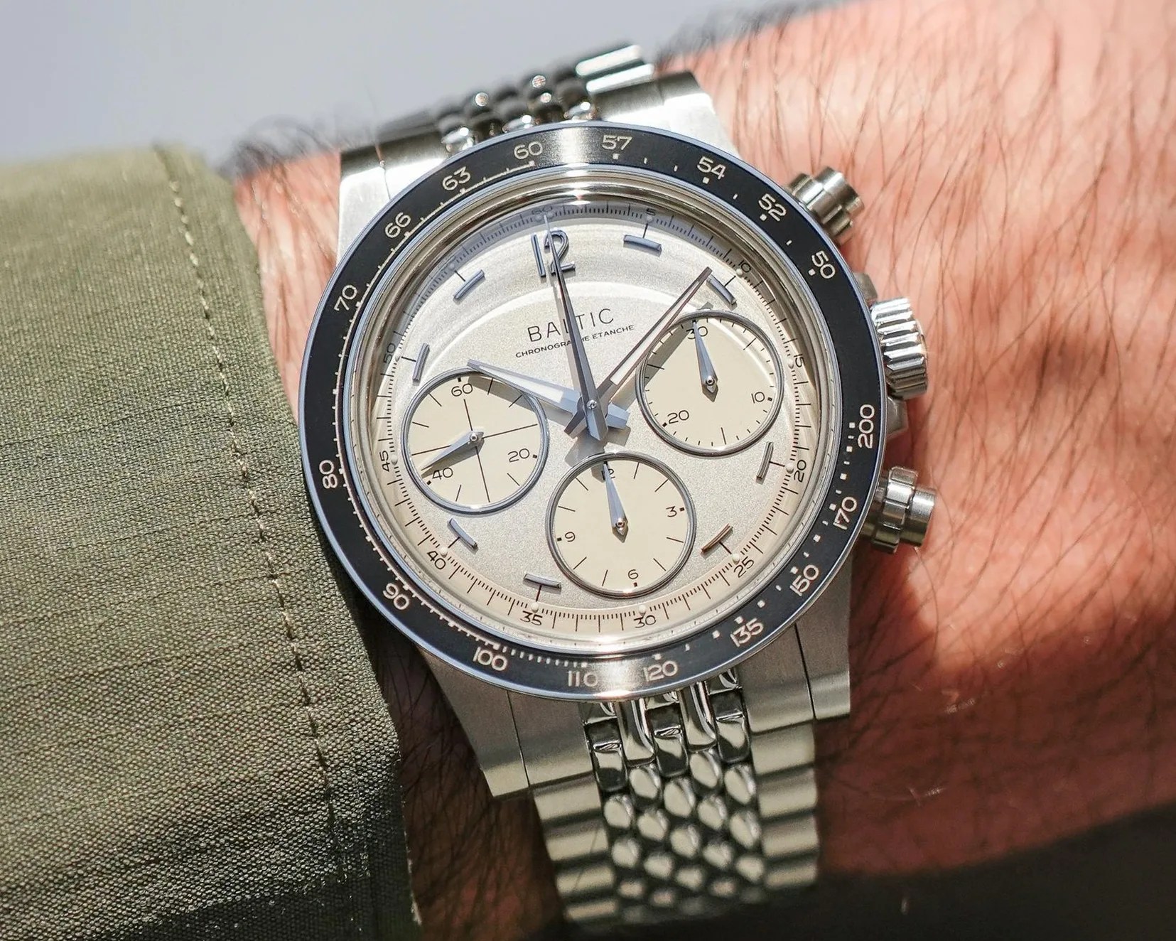 Silver Baltic chronograph wristwatch with cream subdials and black bezel on a metal bracelet.