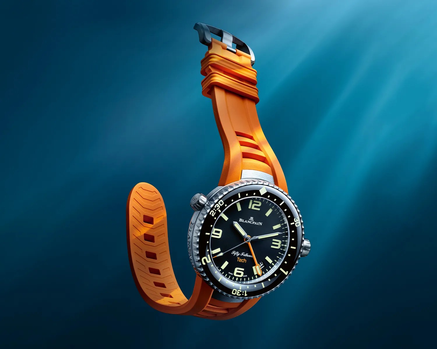 Diver's watch with black dial, luminous markers, and orange rubber strap against a blue underwater background.