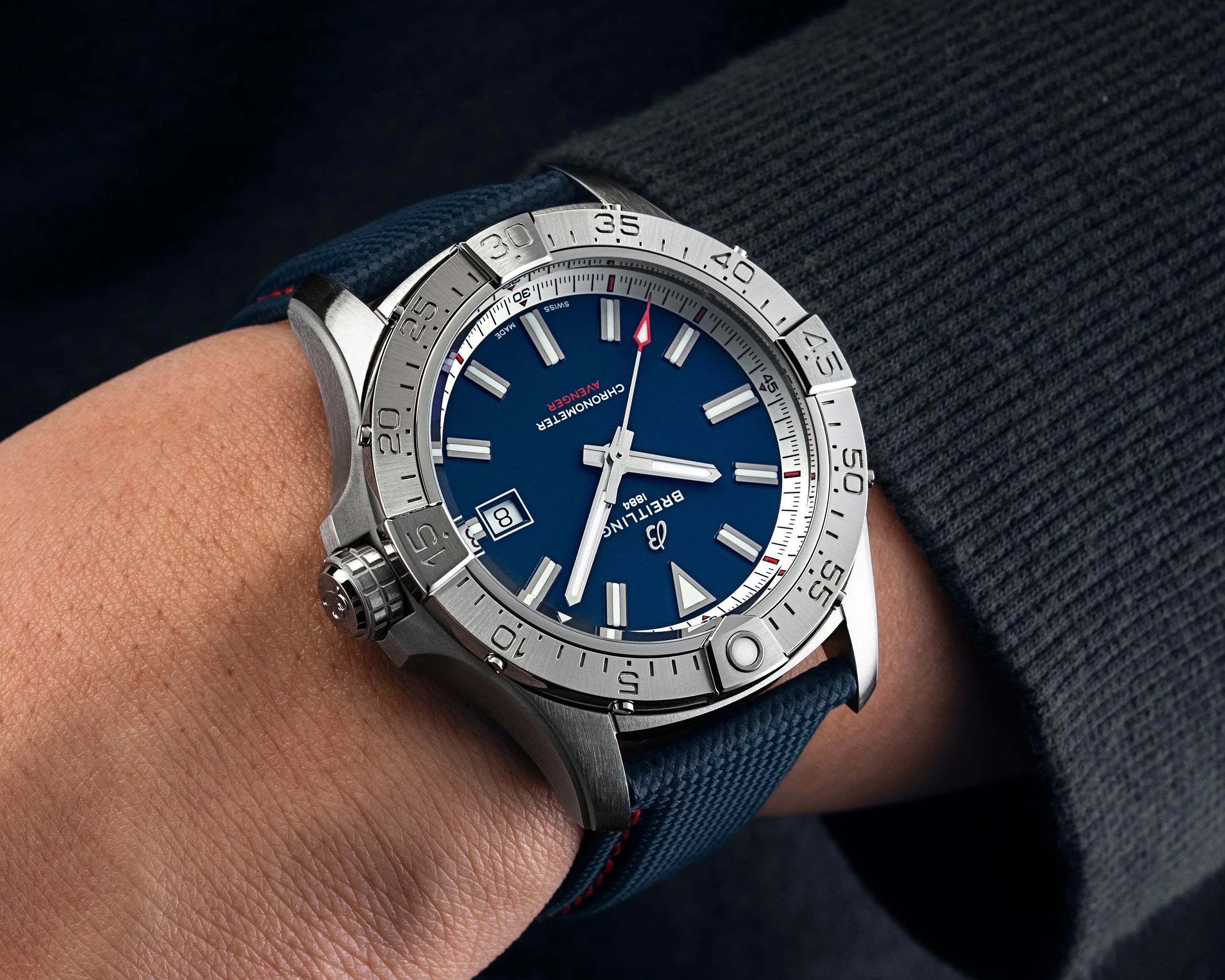 Stainless steel Breitling Avenger chronometer watch with blue dial and date window on a blue textured strap.