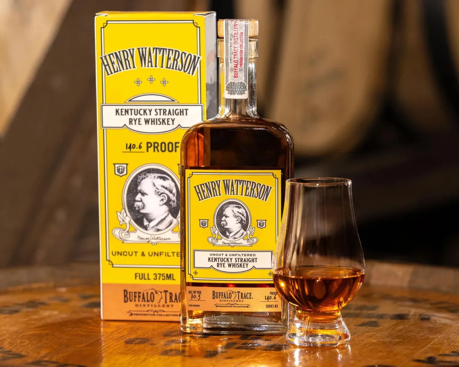Bottle and box of Henry Watterson Kentucky Straight Rye Whiskey with a filled whiskey glass on a wooden surface.