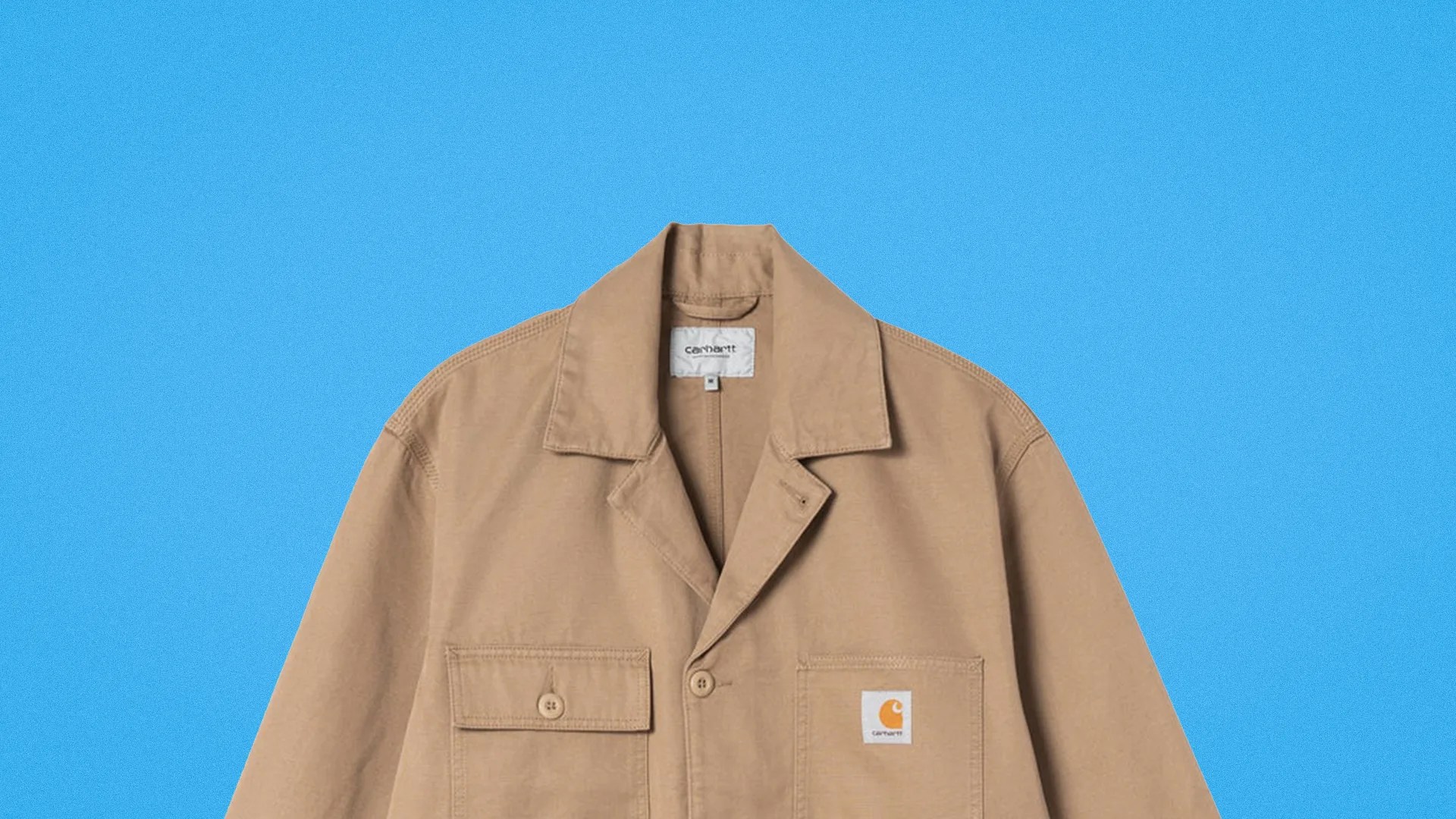 Tan Carhartt work jacket with buttoned chest pockets on a blue background.