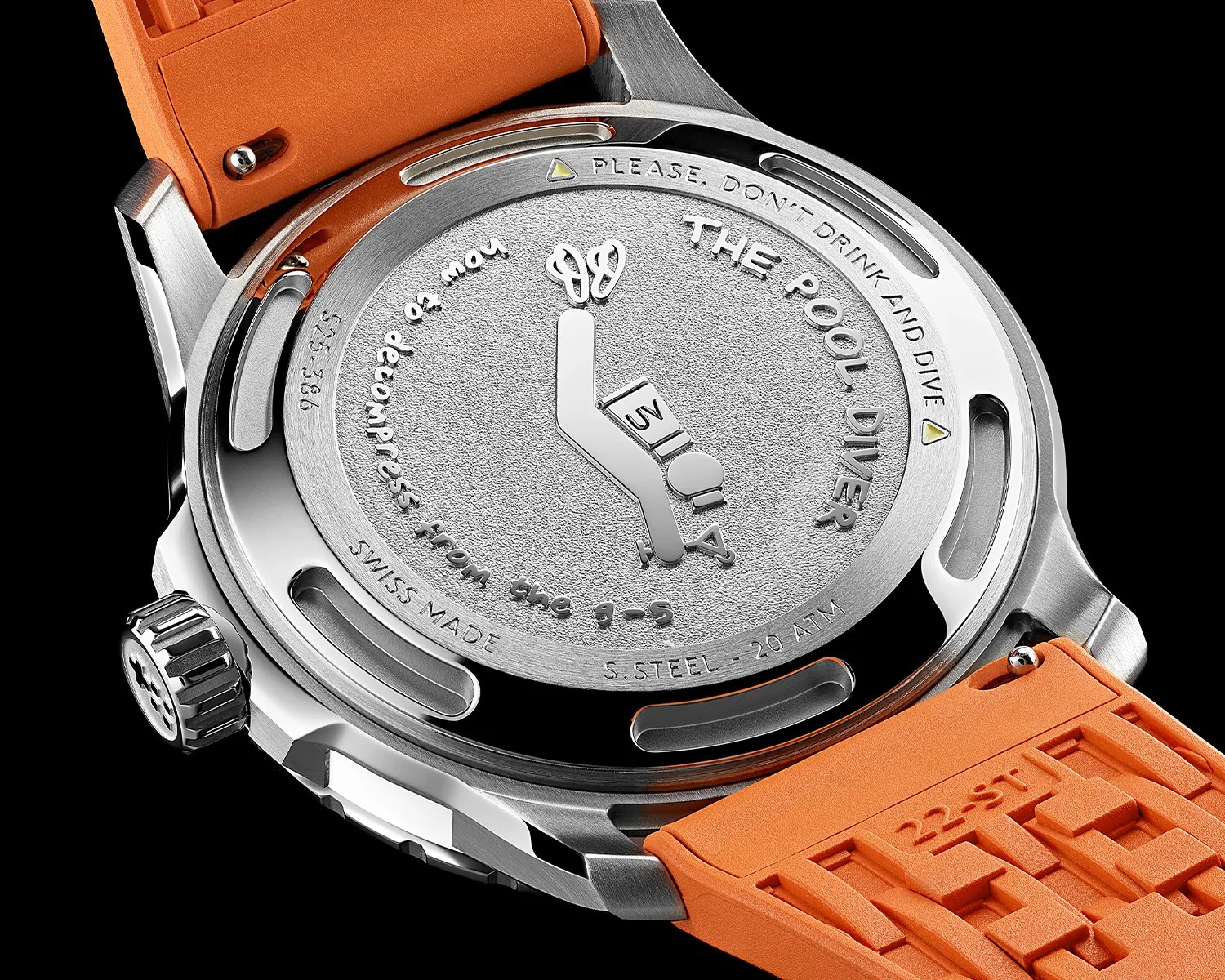 Close-up of a stainless steel watch back with engraved diver icon and text, attached to an orange rubber strap.