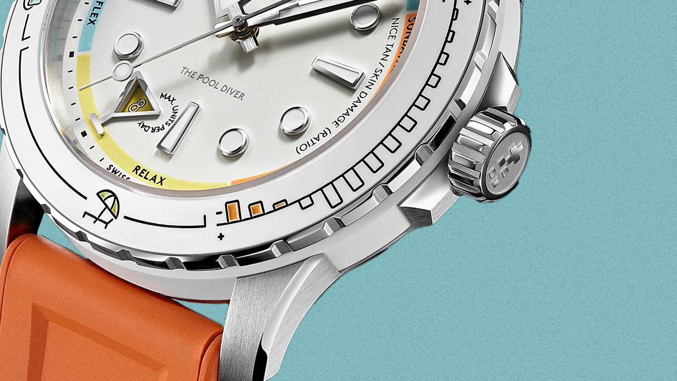 Close-up of a silver diver's watch with a white dial, orange rubber strap, and detailed bezel markings.
