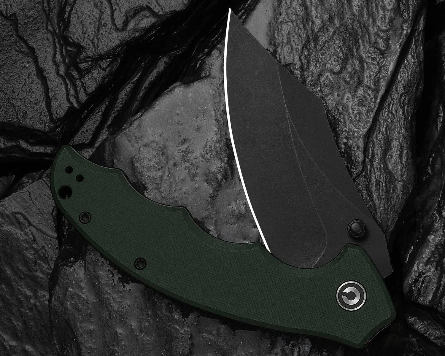 Folding knife with a black blade and dark green textured handle on a textured black surface.