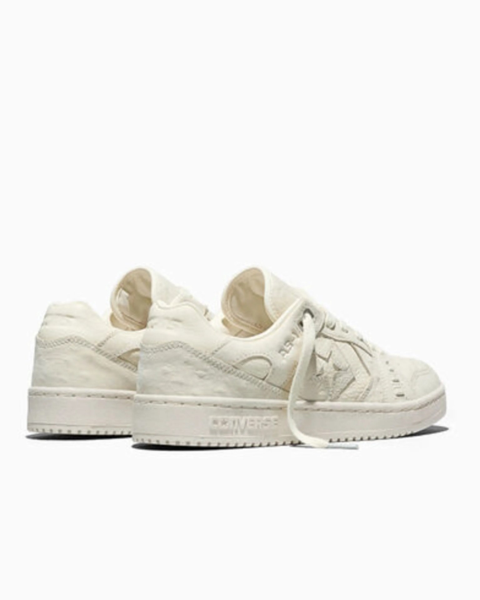 Pair of off-white Converse sneakers with star logo and laces, shown from the back and side.