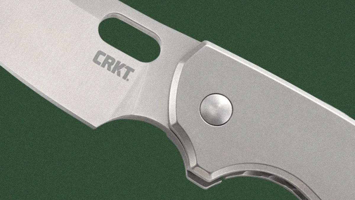 Close-up of a silver folding knife blade and handle with "CRKT" logo on the blade.