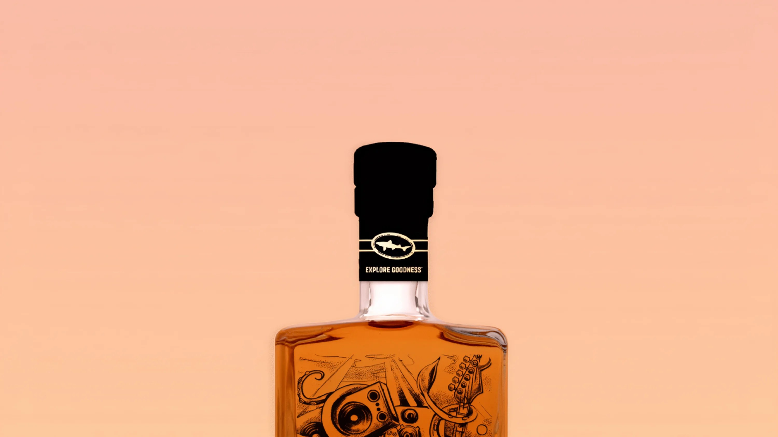 Top portion of a whiskey bottle with a black cap labeled "Explore Goodness" against a peach background.