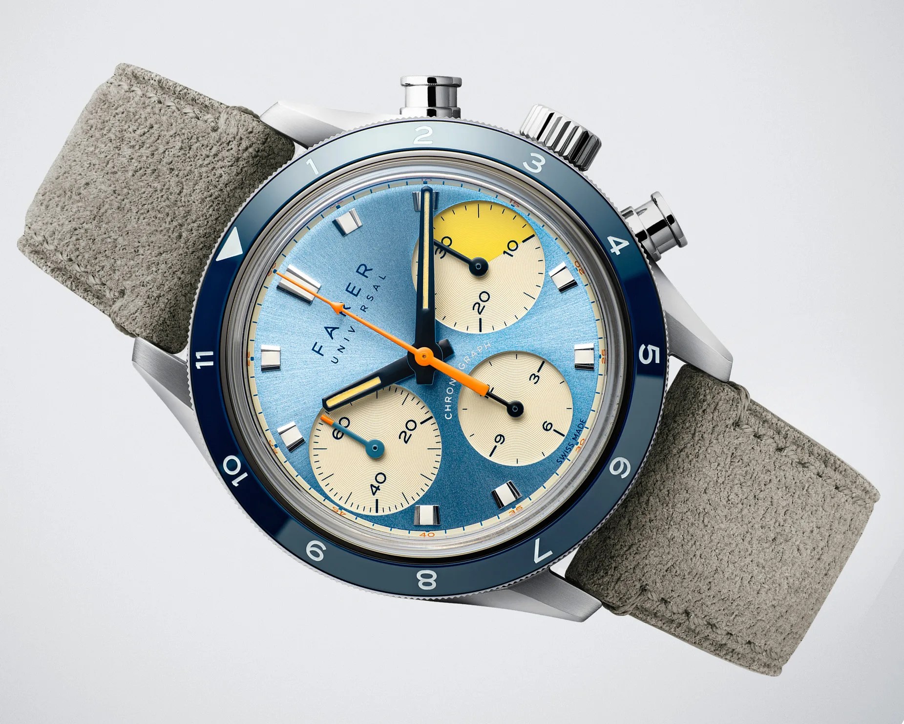 Blue dial chronograph wristwatch with cream subdials, orange and blue hands, blue bezel, and gray suede strap.