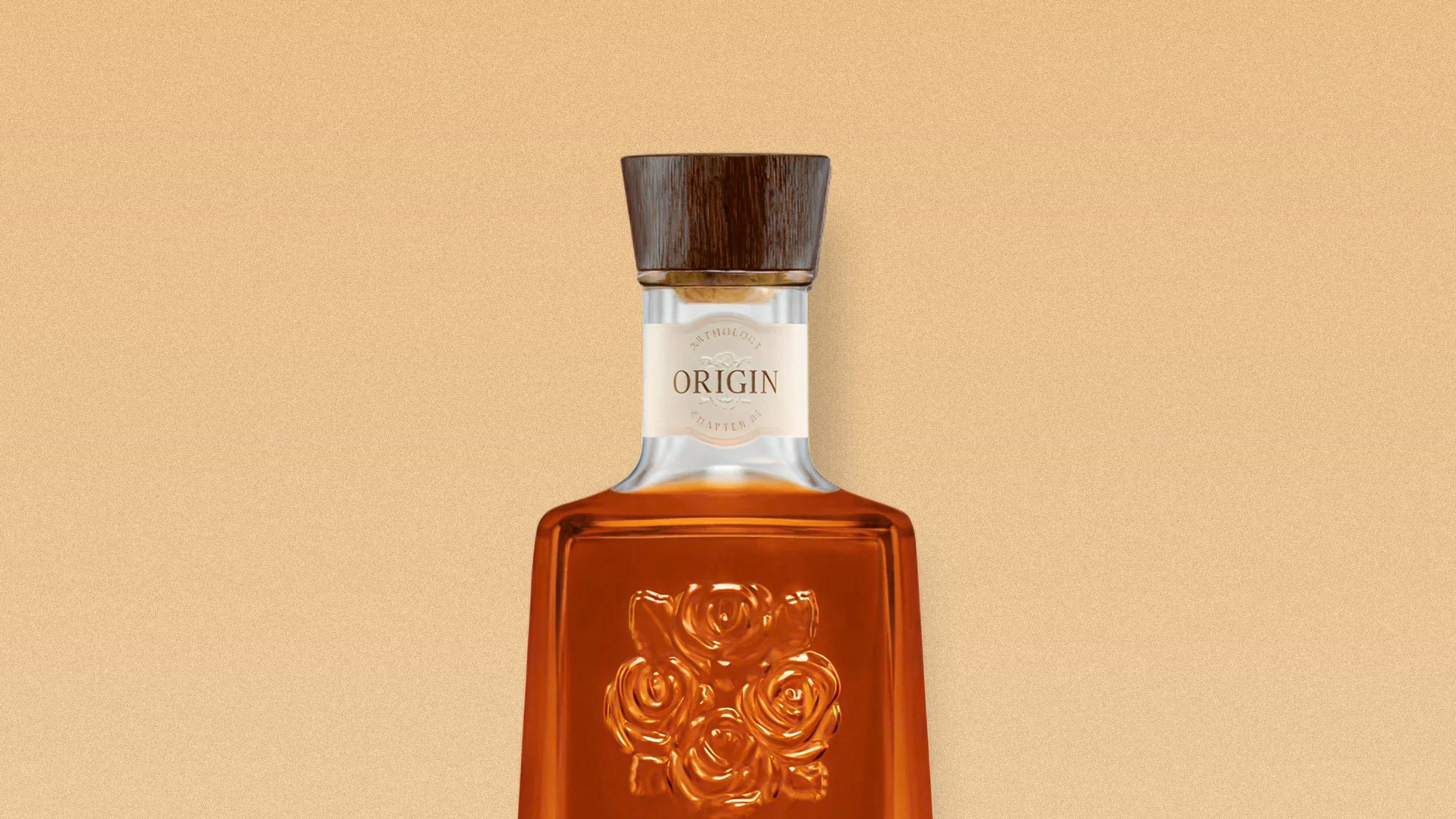 Amber glass bottle with embossed roses and a wooden cap labeled "Origin" on a beige background.