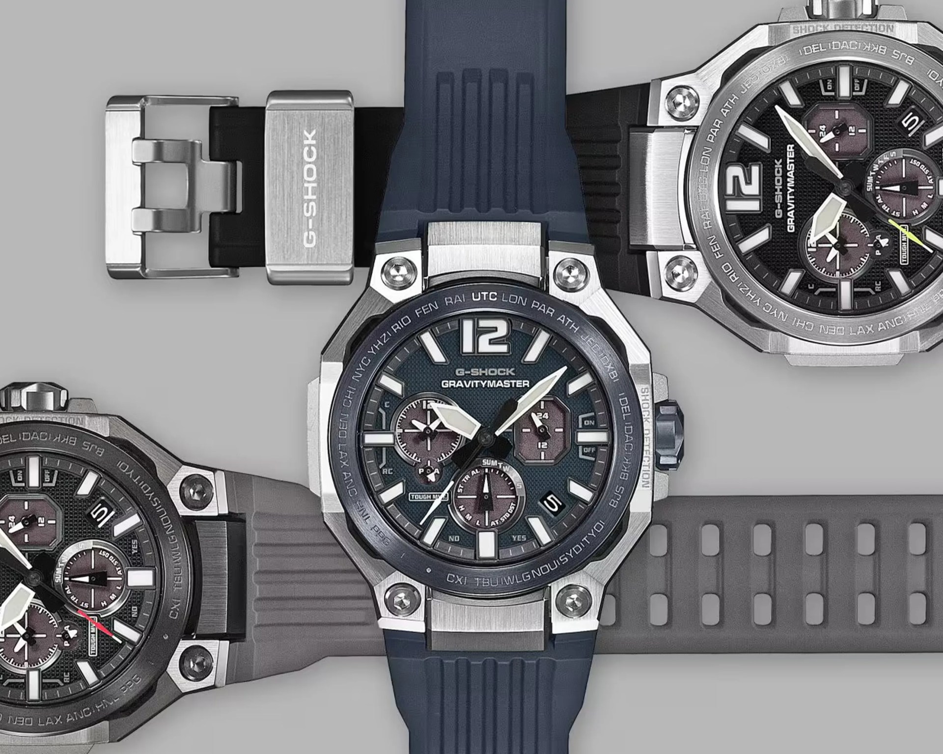 Three G-Shock Gravitymaster watches with stainless steel cases and black dials, featuring blue, black, and gray resin straps.