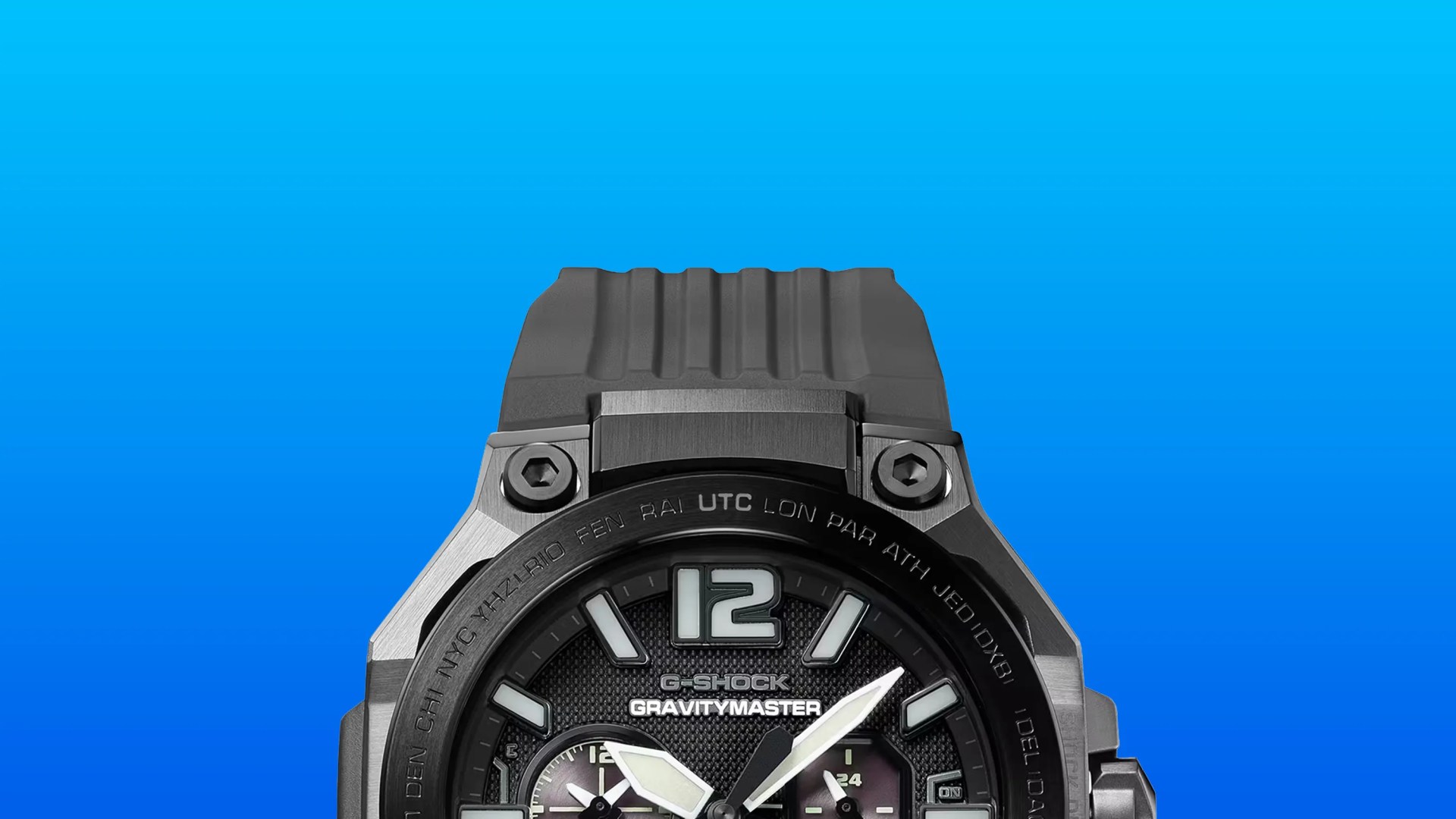 Partial view of a black G-Shock Gravitymaster watch with a textured dial and luminous hands against a blue background.