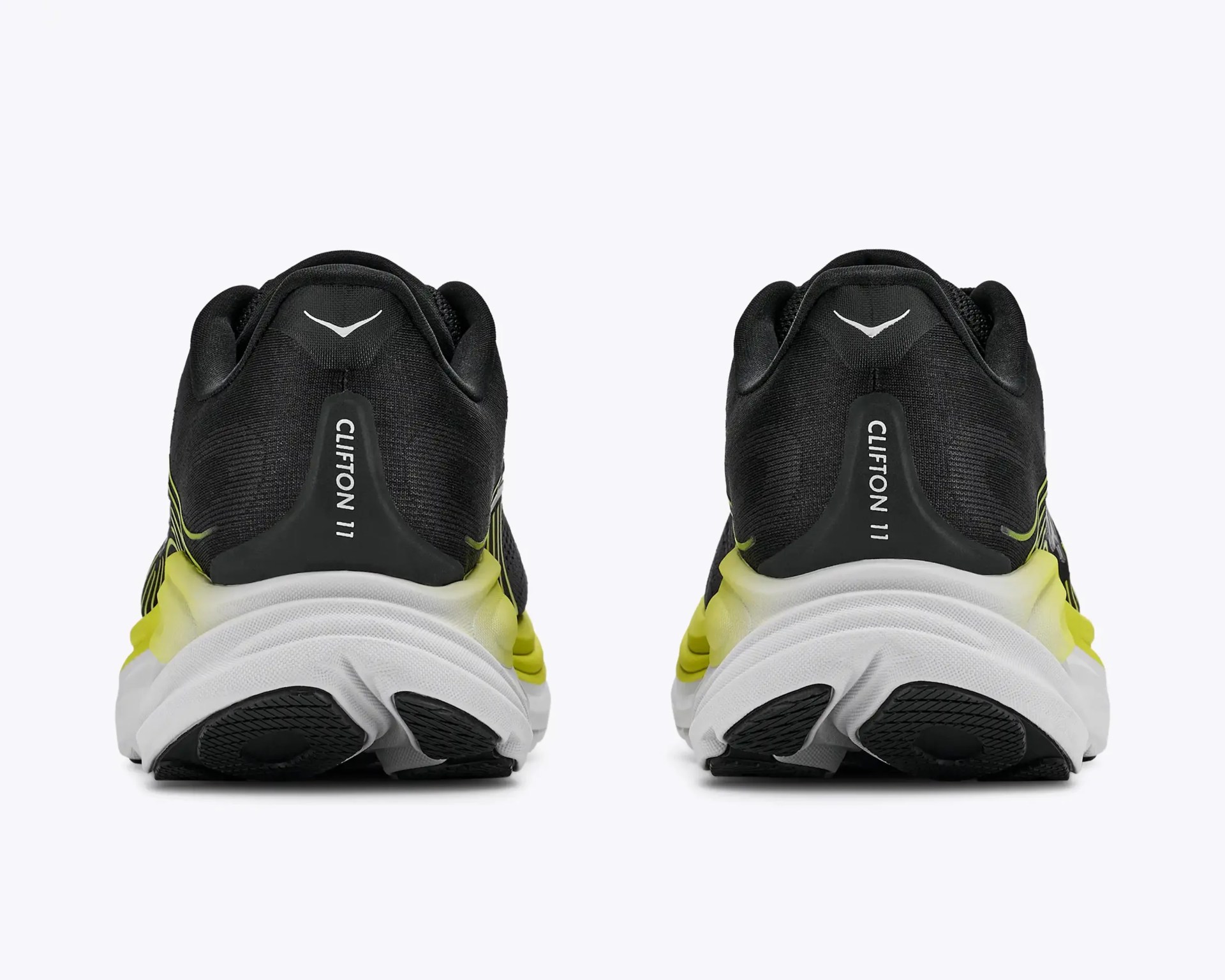 Pair of black and yellow running shoes with white soles viewed from the back.