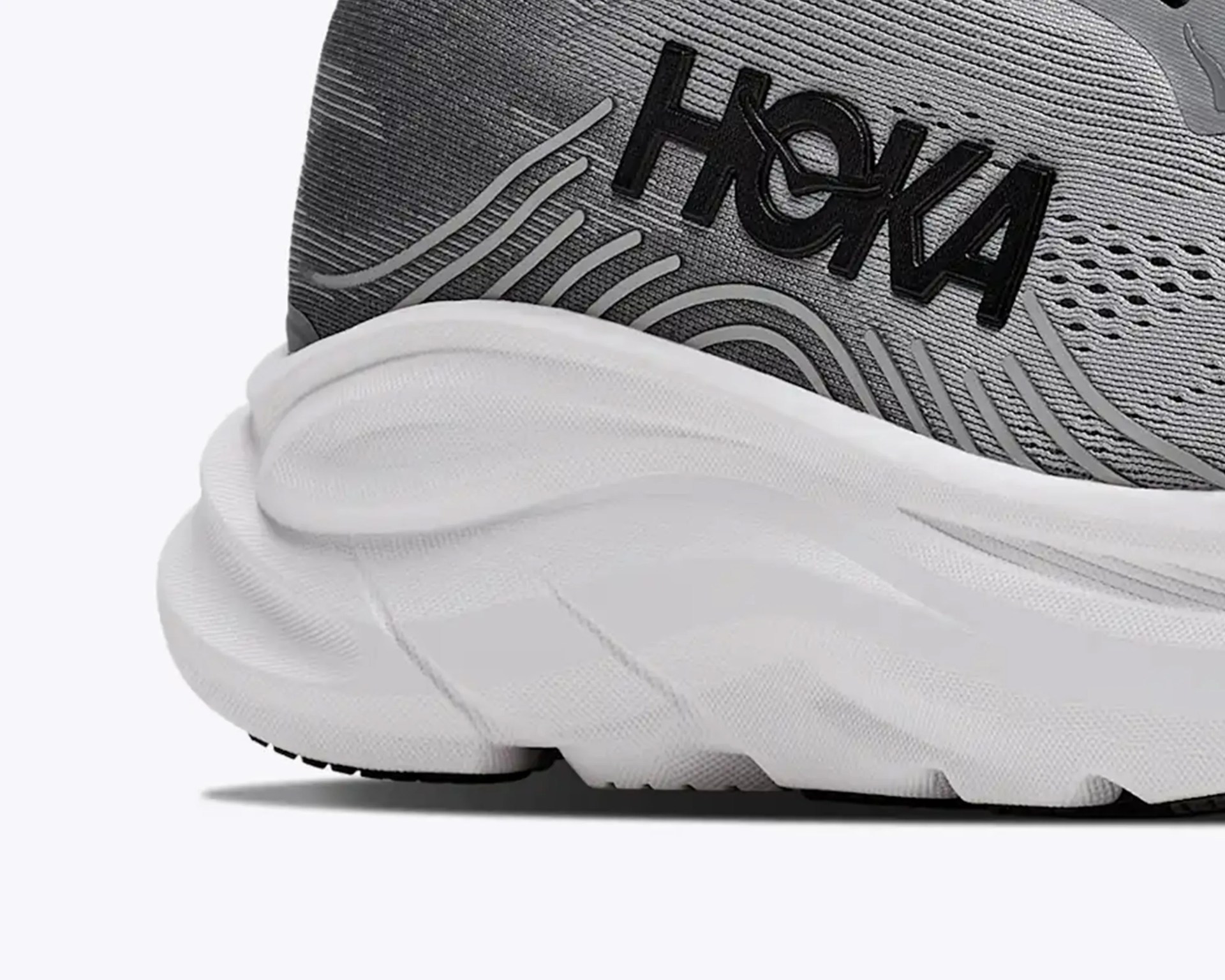 Close-up of a gray HOKA running shoe heel with black logo and white cushioned sole.