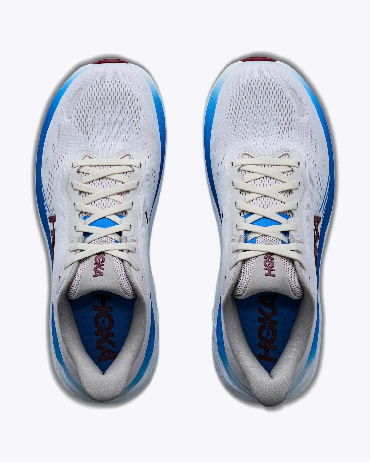 Pair of white running shoes with blue accents and beige laces viewed from above.