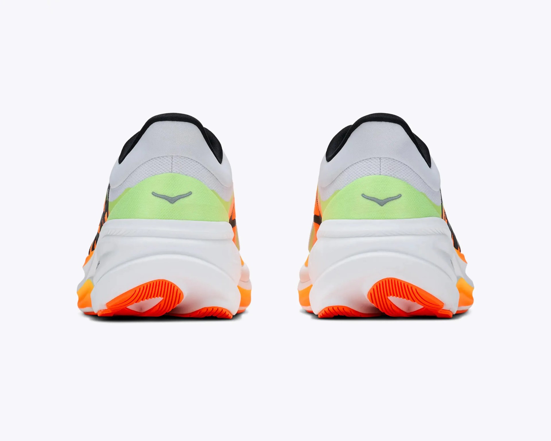 Pair of white athletic shoes with neon green accents and bright orange soles shown from the back.