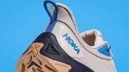 Close-up of the heel and sole of a beige and blue Hoka sneaker with a textured tan outsole.