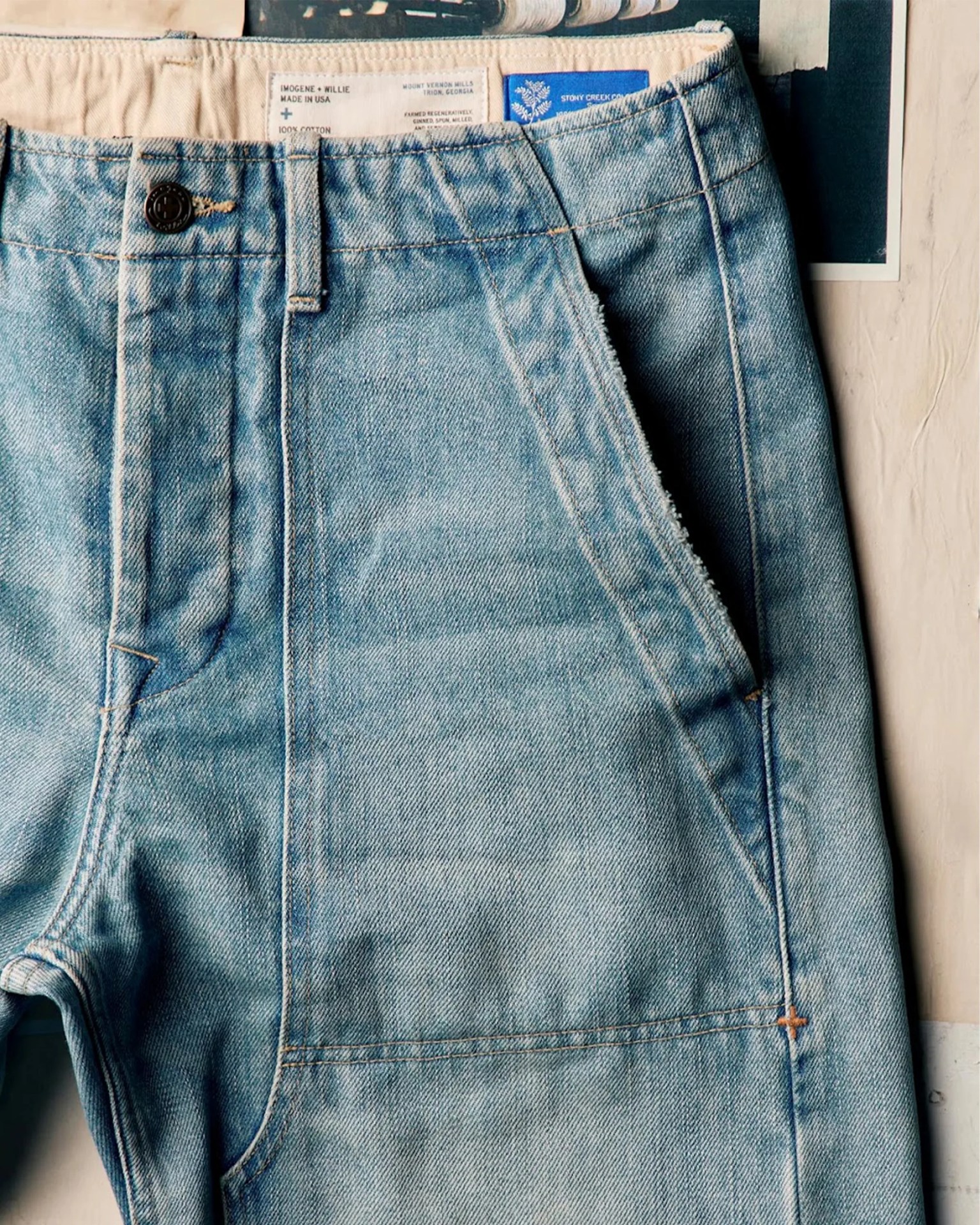 Light blue denim jeans with a button closure and visible front pocket stitching.