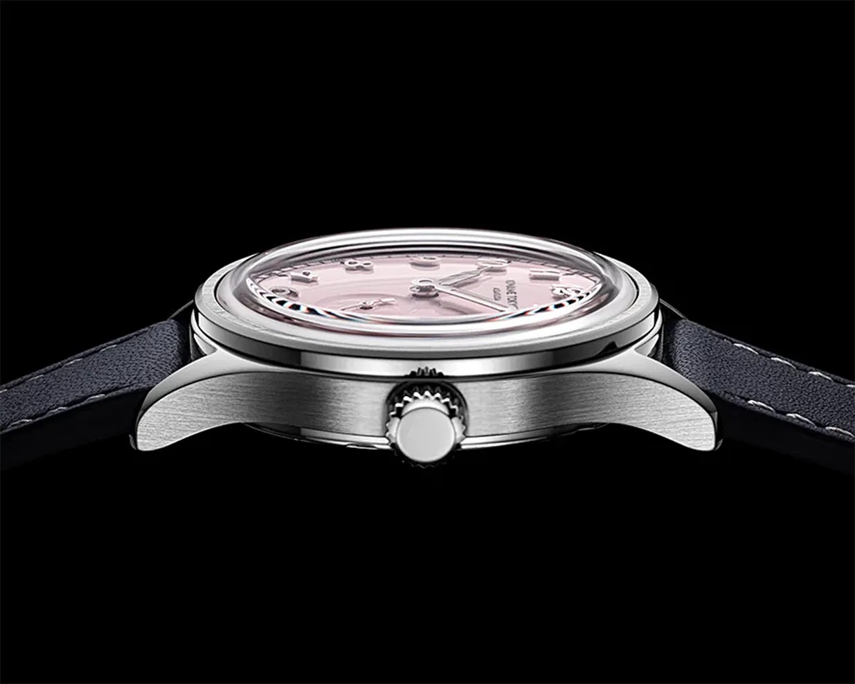 Side view of a silver wristwatch with a domed crystal and a pink dial, attached to a black leather strap.