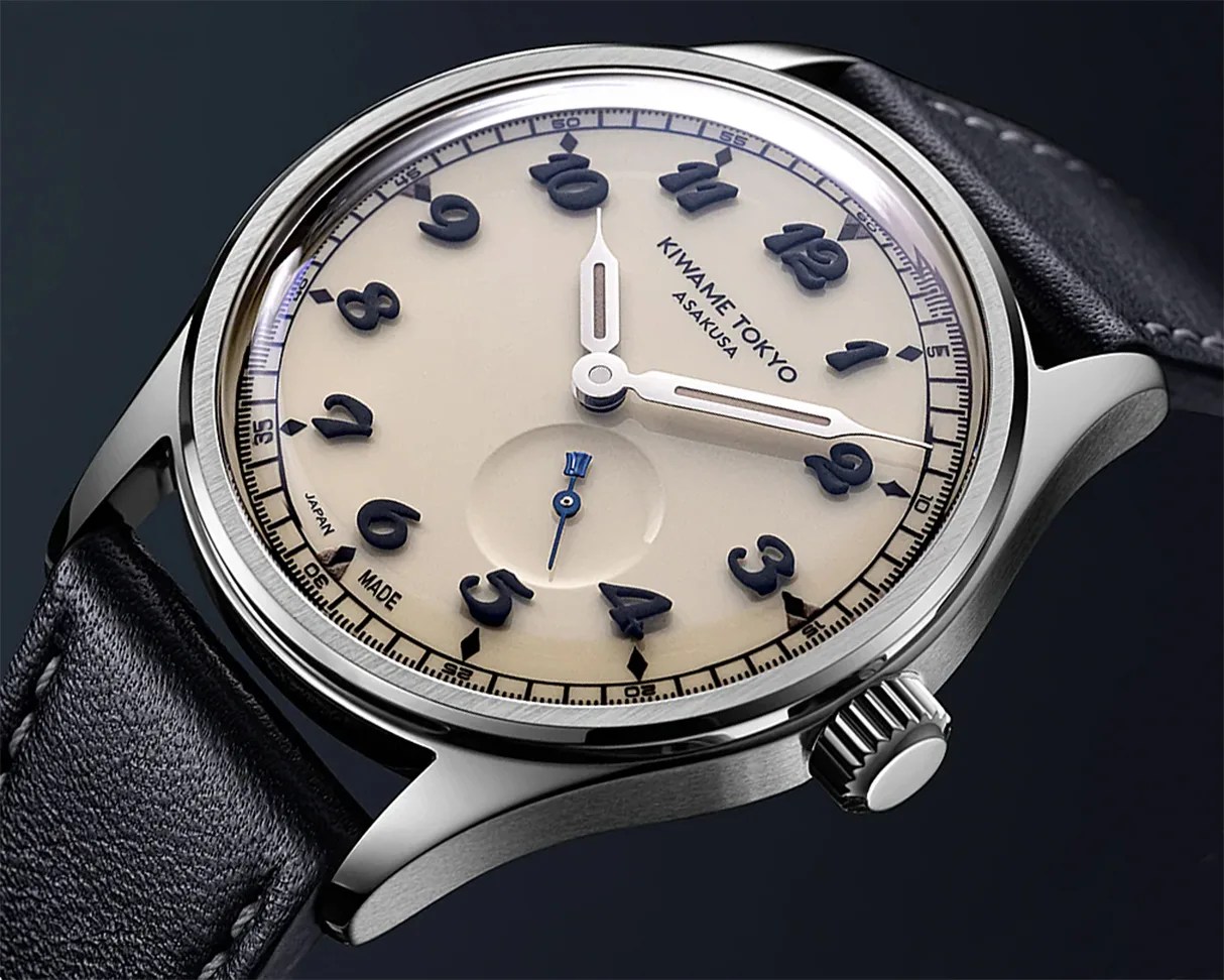 Close-up of a Kiwame Tokyo Asakusa wristwatch with a cream dial, black raised numerals, silver hands, and a black leather strap.