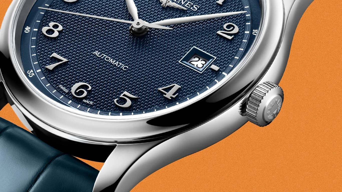 Close-up of a silver wristwatch with a textured blue dial, white numerals, date window, and blue leather strap on an orange background.