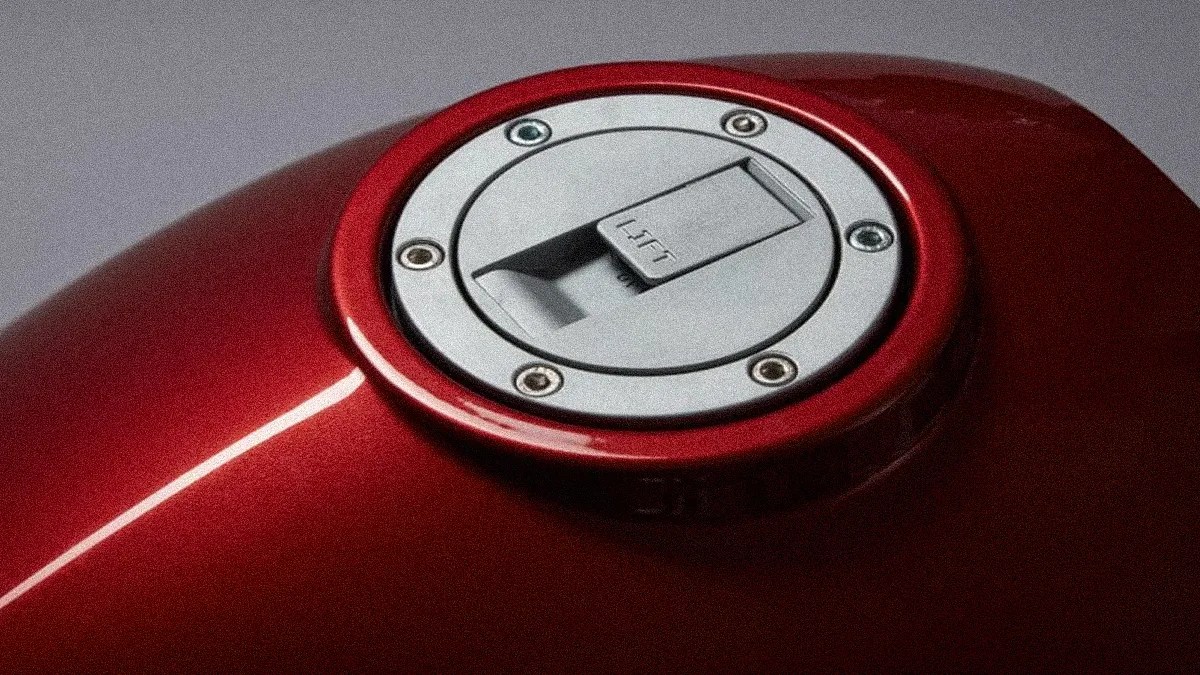 Close-up of a red motorcycle fuel tank with a silver circular fuel cap labeled "LIFT.