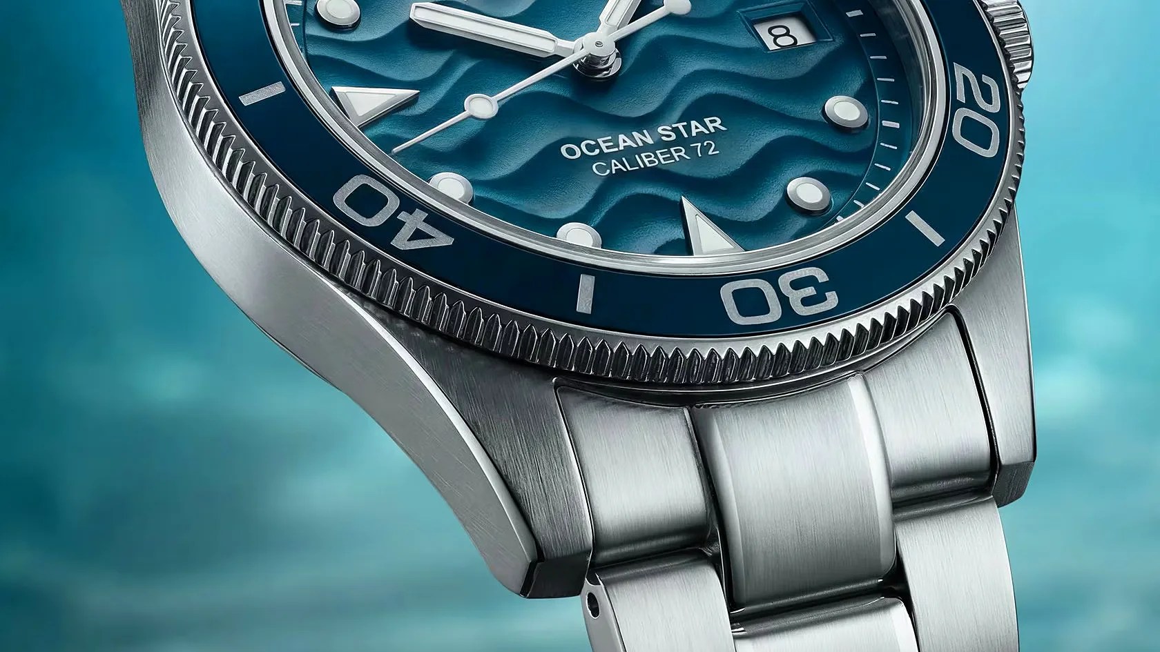 Close-up of a stainless steel Ocean Star Caliber 72 watch with a blue textured dial and rotating bezel.