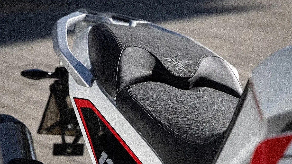Black textured motorcycle seat with a silver logo and white and red body panel visible.