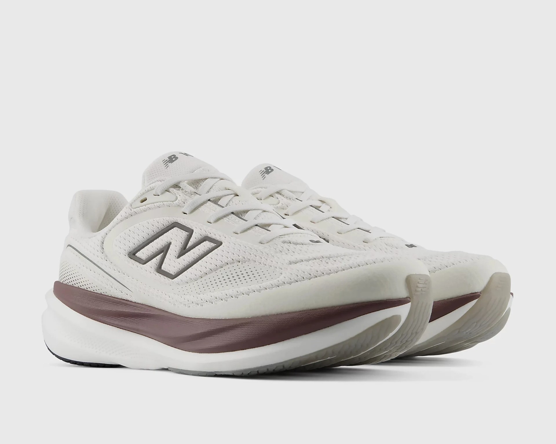 Pair of off-white New Balance running shoes with maroon midsole and mesh upper.