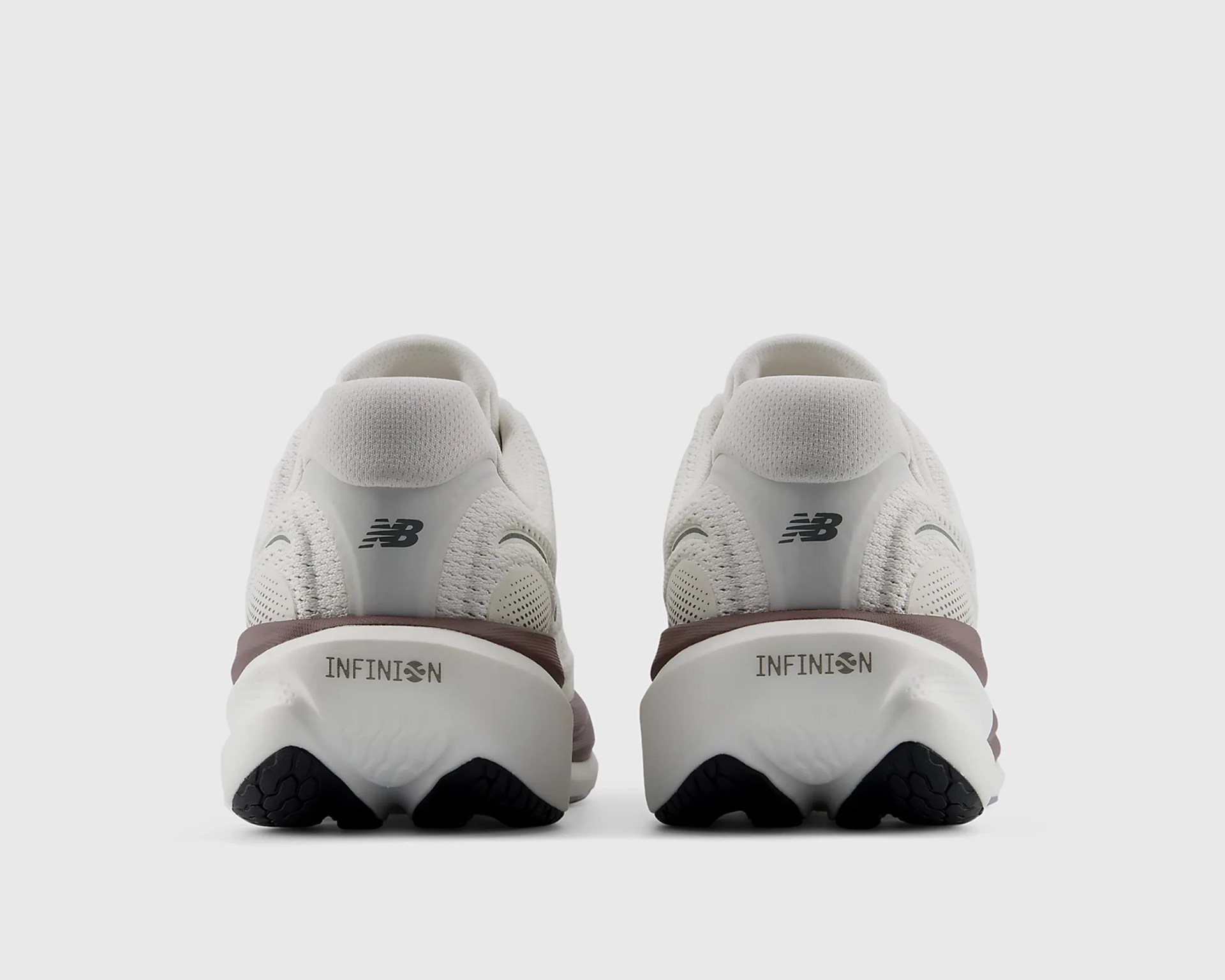Pair of white New Balance sneakers with brown accents and "INFINION" text on the heel viewed from the back.