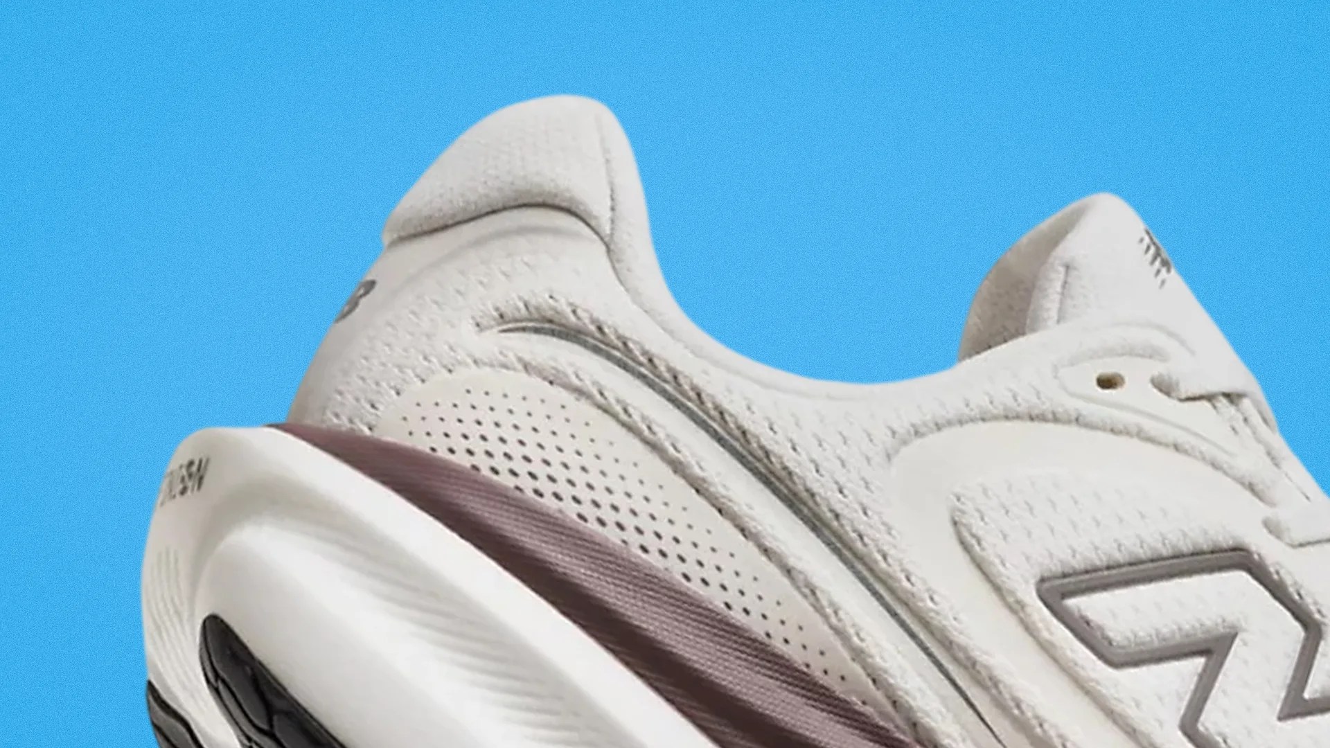 Close-up of the heel and side of a white New Balance sneaker with a maroon midsole against a blue background.
