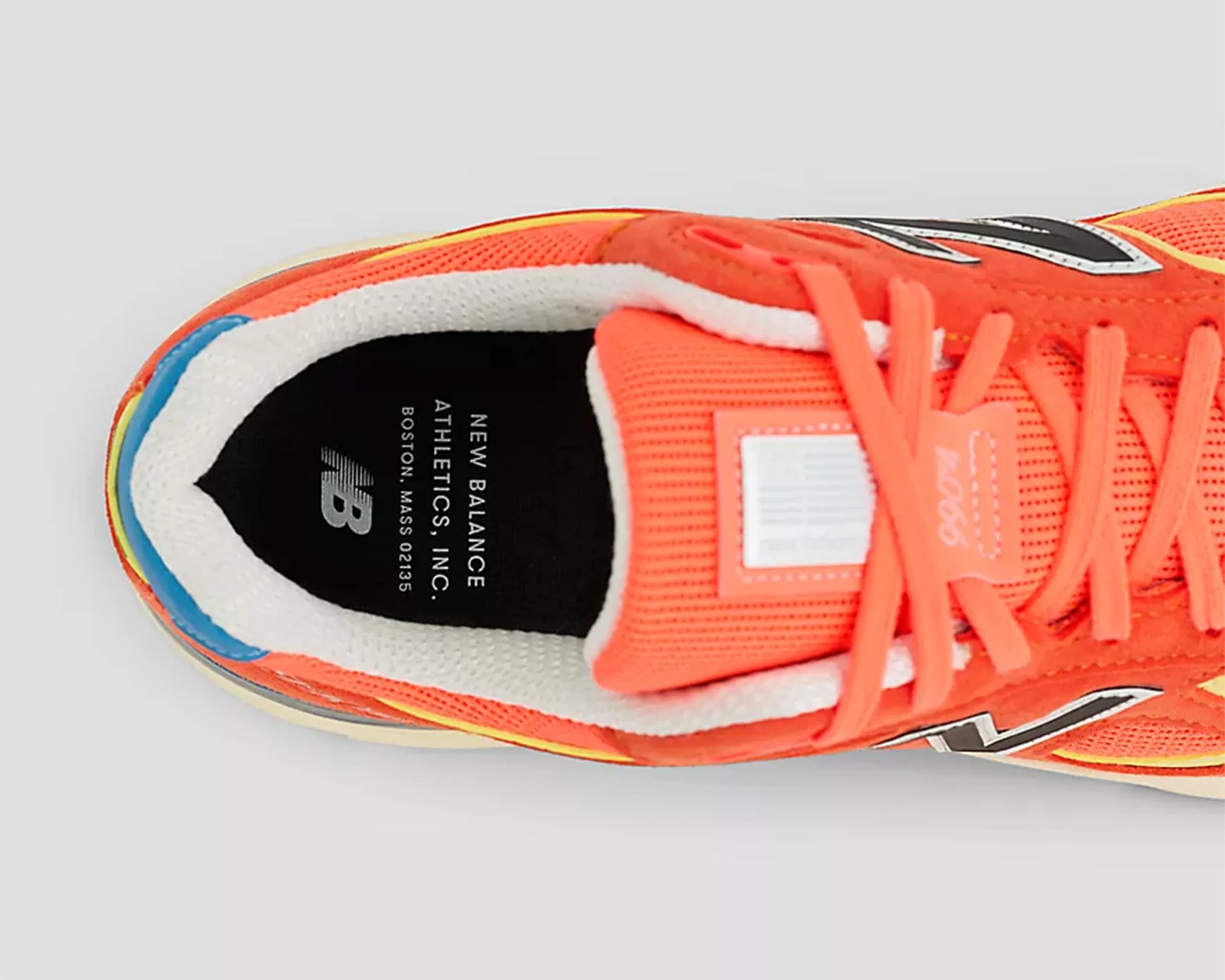 Top view of an orange New Balance sneaker with white padded collar and black insole text.