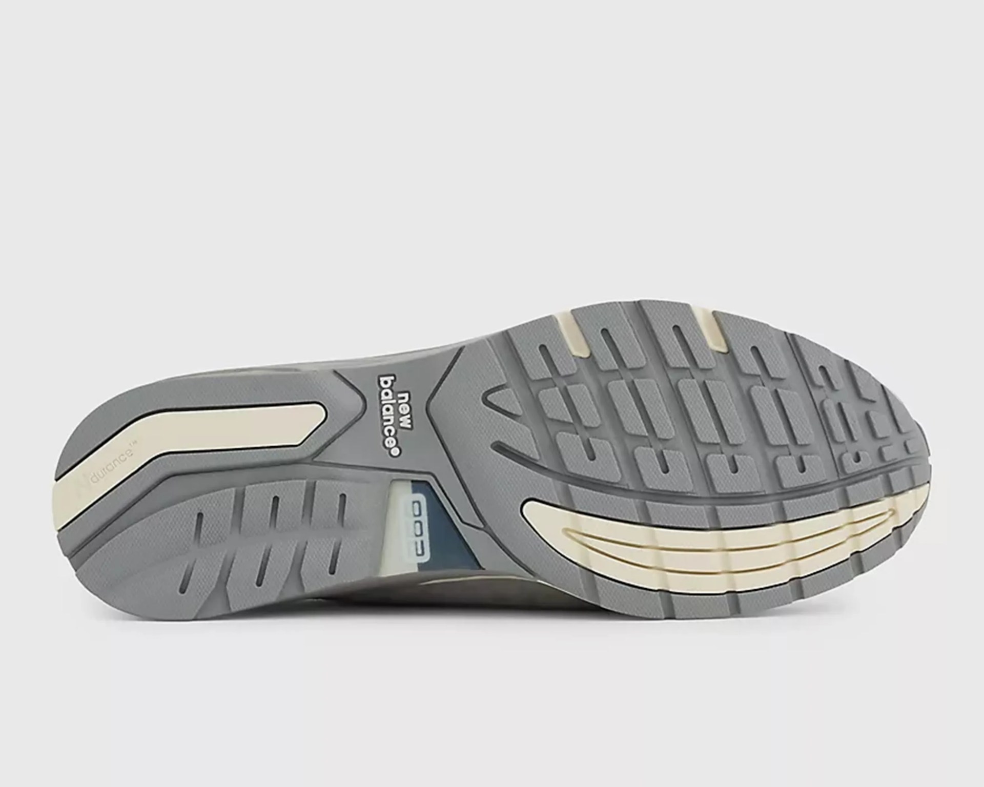 Gray and cream New Balance shoe sole with textured tread and visible cushioning window.