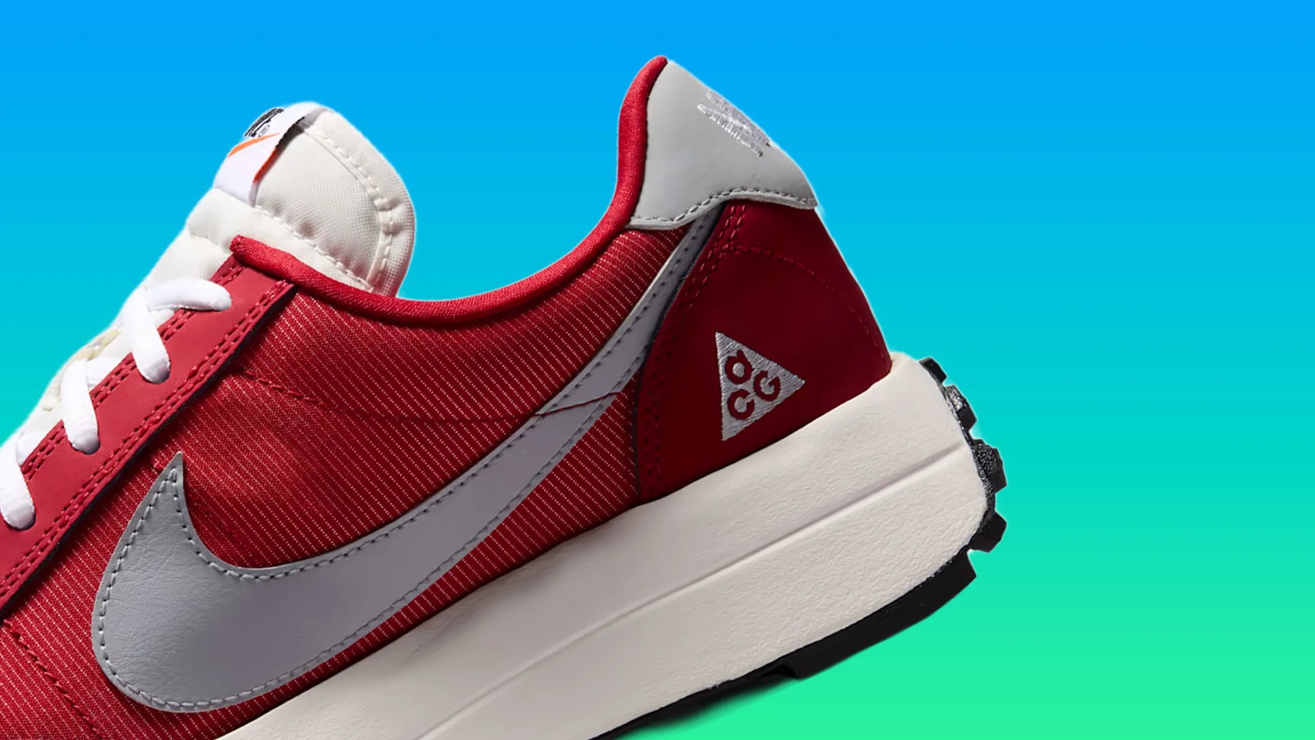 Red and gray Nike ACG sneaker with white laces and a thick white sole against a blue-green gradient background.