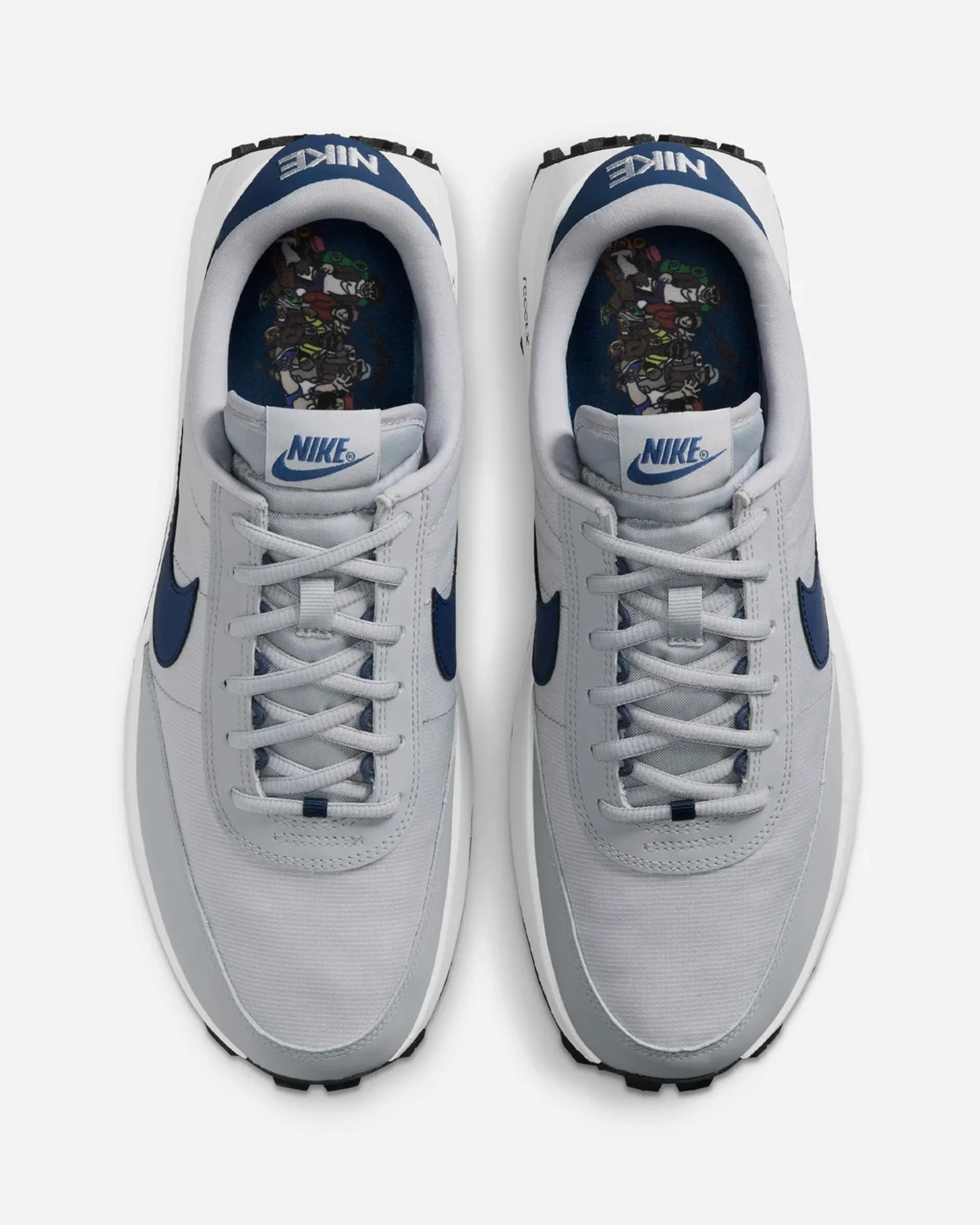 Pair of white and navy Nike sneakers with cartoon character graphics on the insoles.