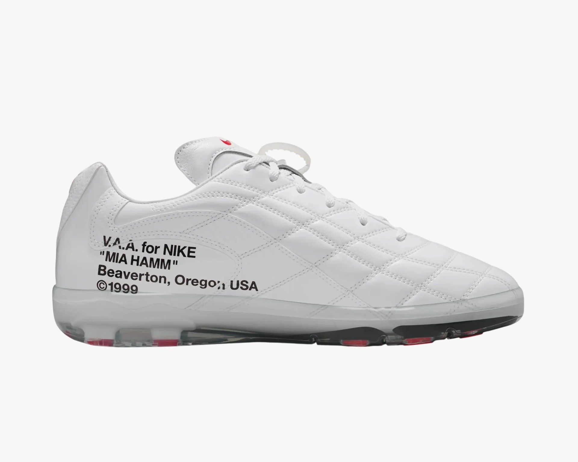 White Nike soccer cleat with black text on the side and red accents on the sole and tongue.