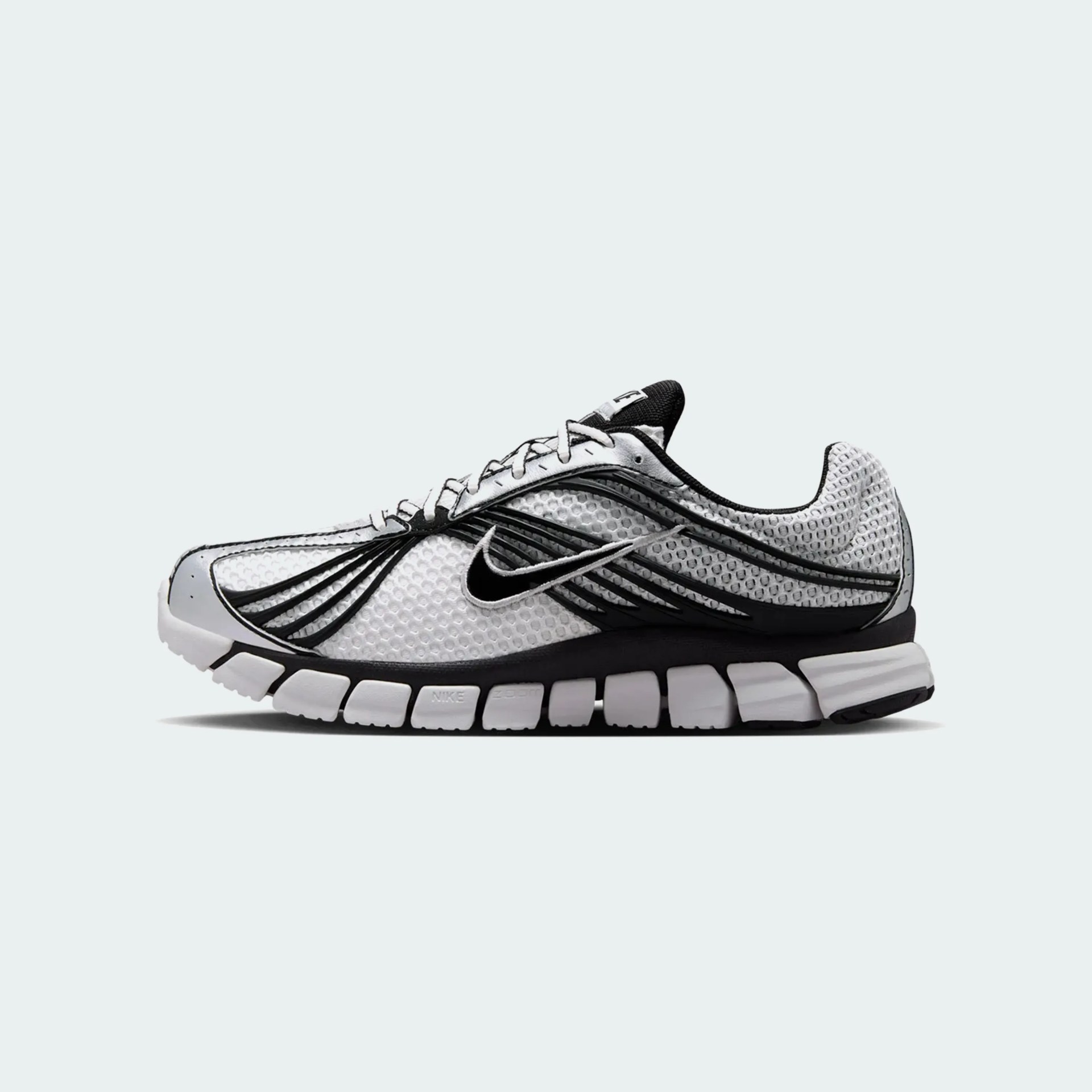 White and black Nike Zoom running shoe with mesh upper and segmented sole.