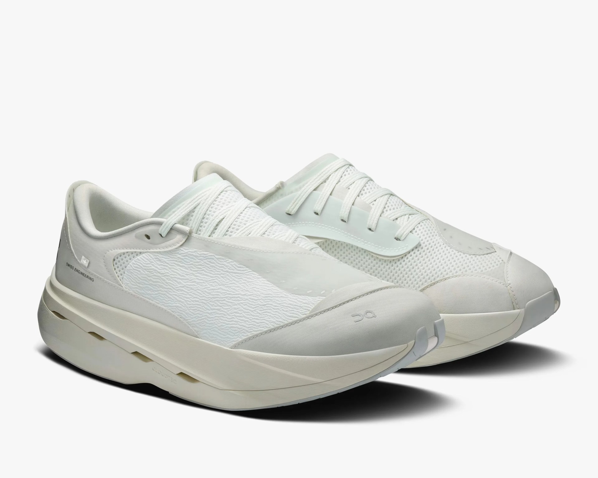 Pair of off-white athletic sneakers with mesh and textured fabric uppers and thick cushioned soles.