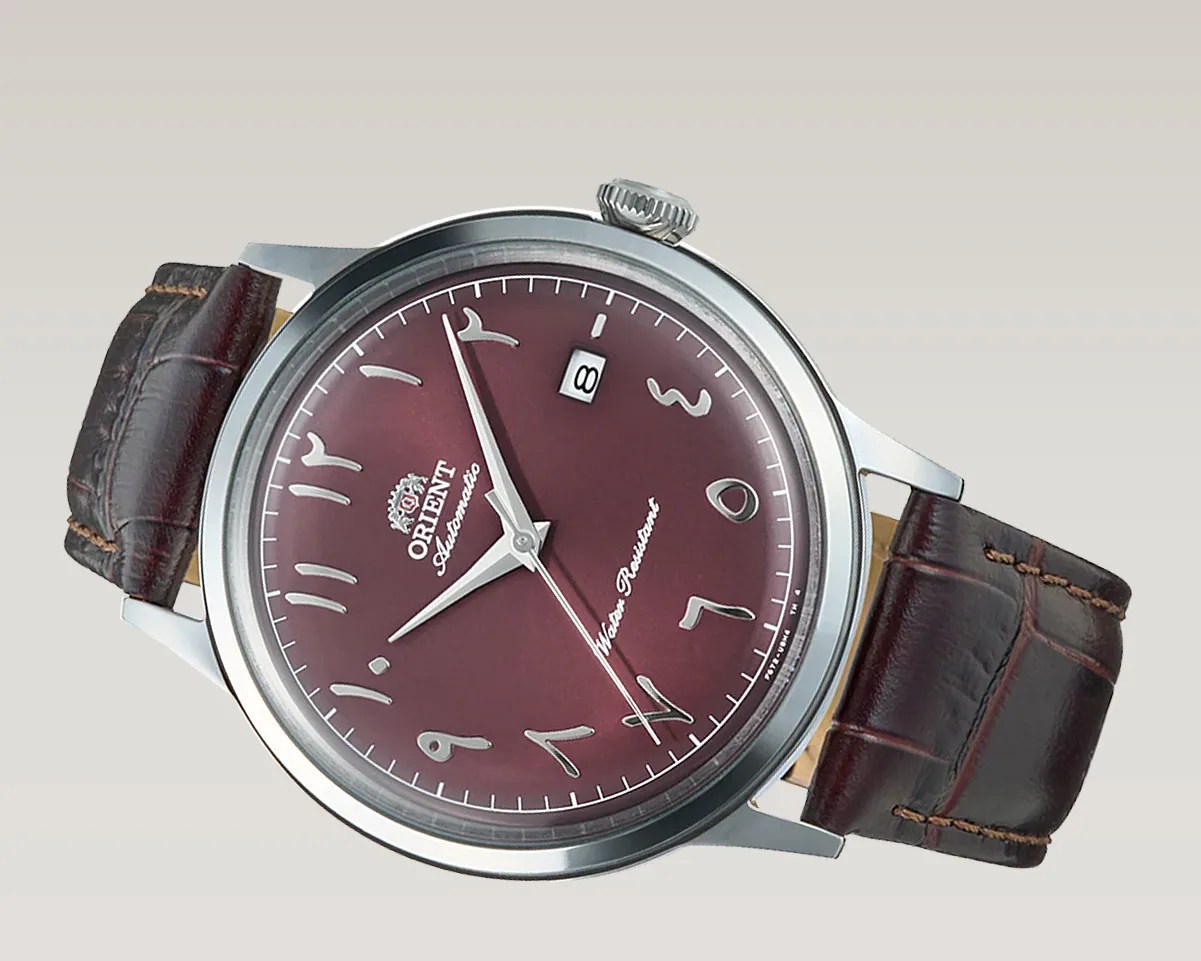 Silver stainless steel watch with burgundy dial featuring Arabic numerals and brown leather strap.