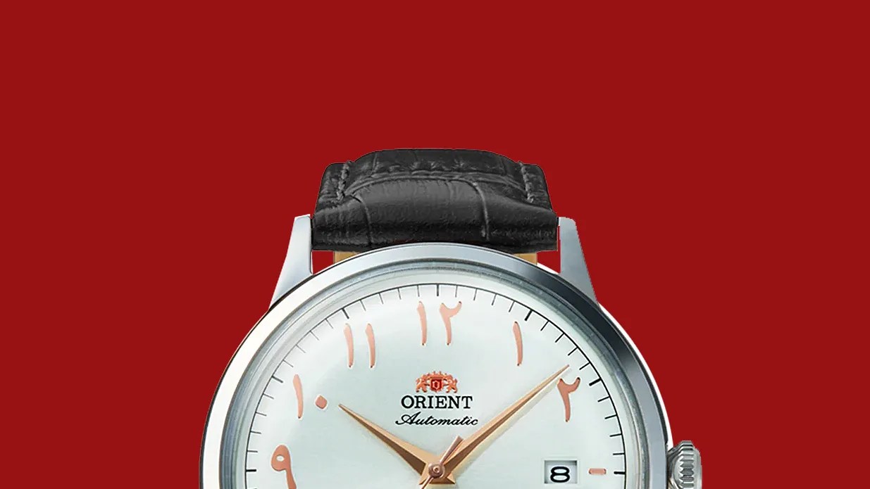 Silver Orient automatic wristwatch with black leather strap and Arabic numerals on white dial.