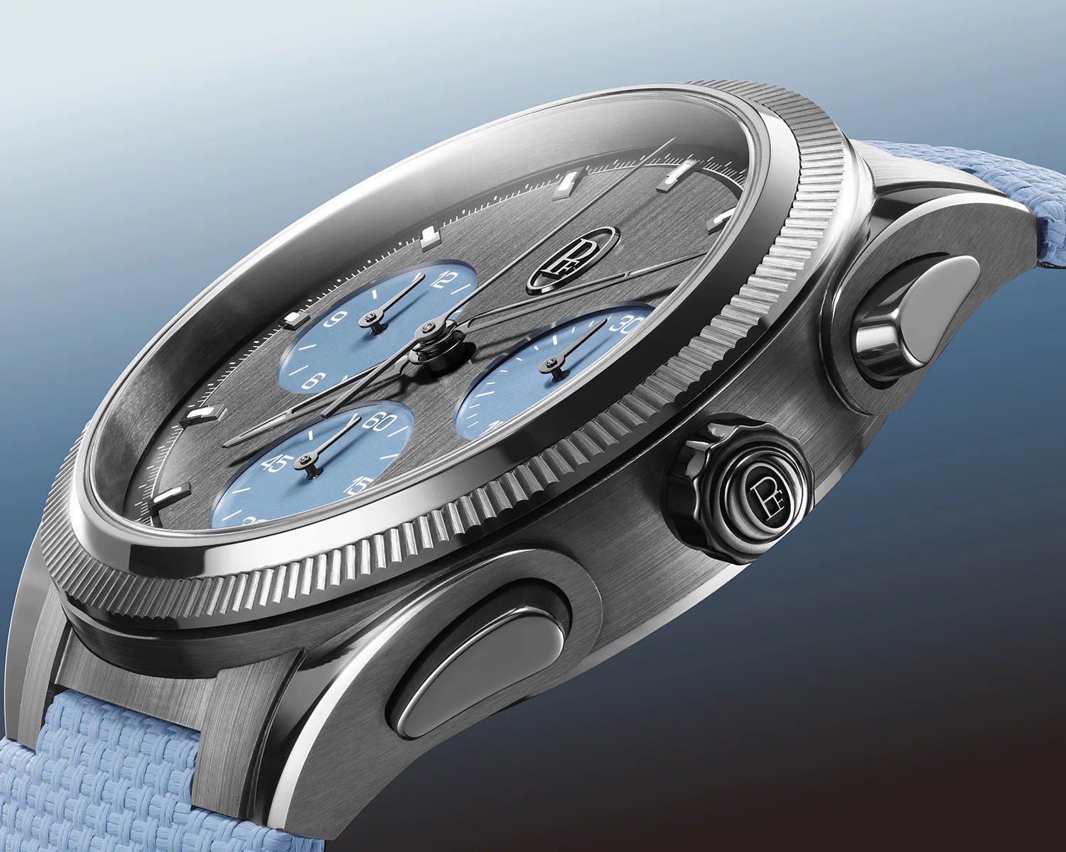 Brushed stainless steel chronograph watch with blue subdials and light blue woven strap.