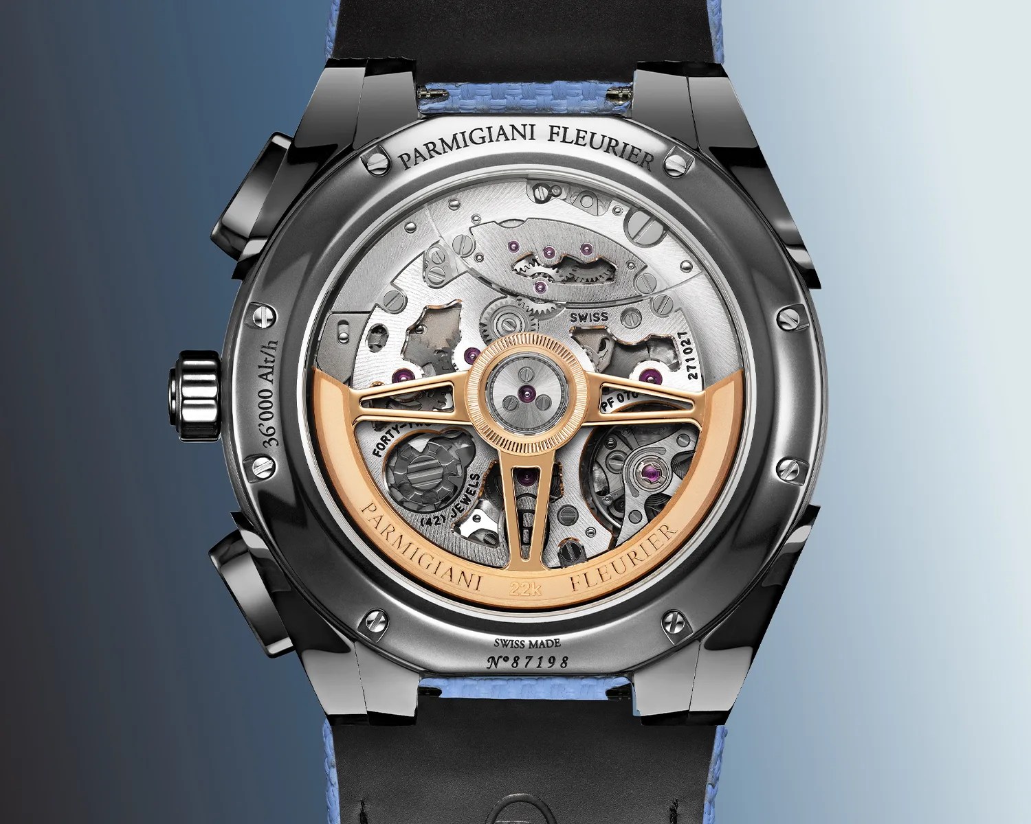 Back view of a Parmigiani Fleurier watch showing the intricate mechanical movement with a 22k gold rotor and blue strap.