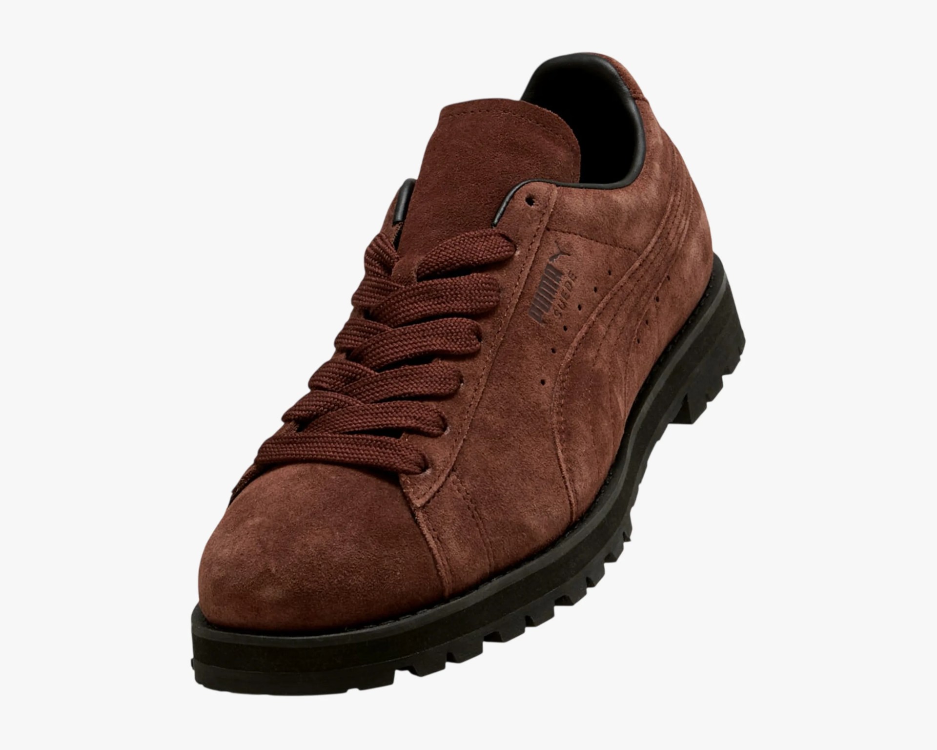 Brown suede Puma sneaker with thick black sole and matching brown laces.